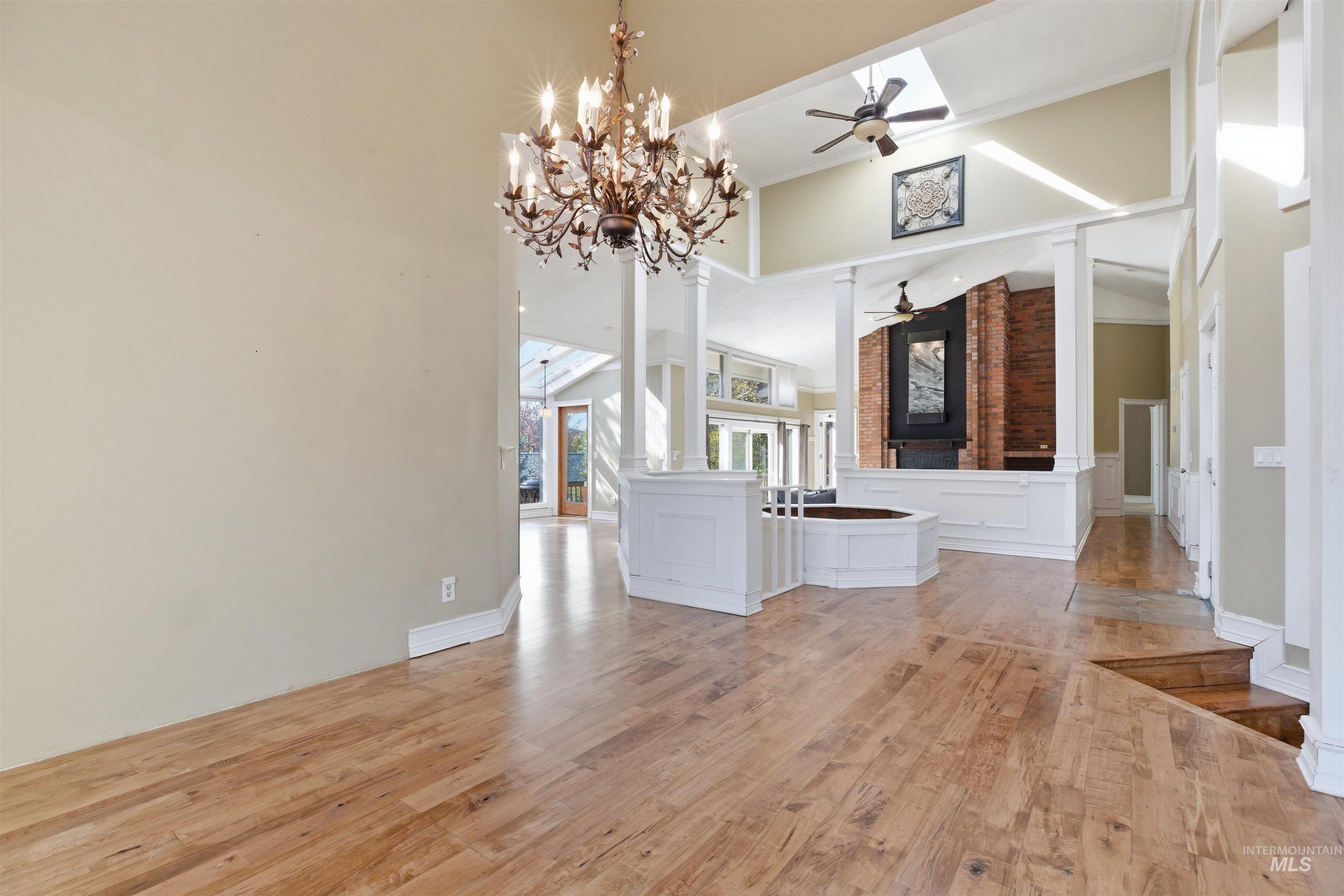1540 Pine Cone Road Moscow, ID 83843 - Photo 6 of 49 Open-concept living space featuring wood-finish flooring, a decorative chandelier, and a brick fireplace