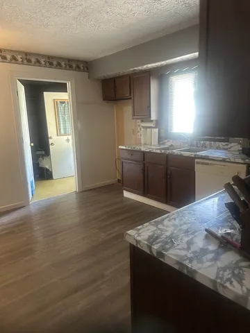 a kitchen with granite countertop a stove cabinets and wooden floor