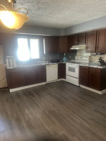a kitchen with granite countertop white cabinets and stainless steel appliances