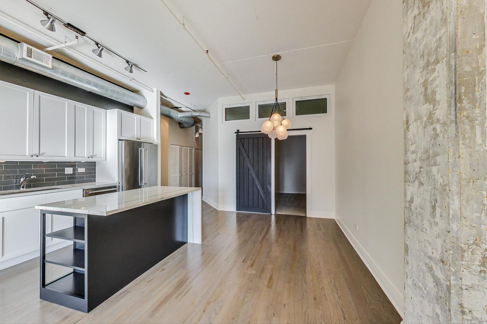 950 West Monroe Street, Unit 608 Chicago, IL 60607 - Photo 15 of 44 a view of kitchen with refrigerator microwave and wooden floor