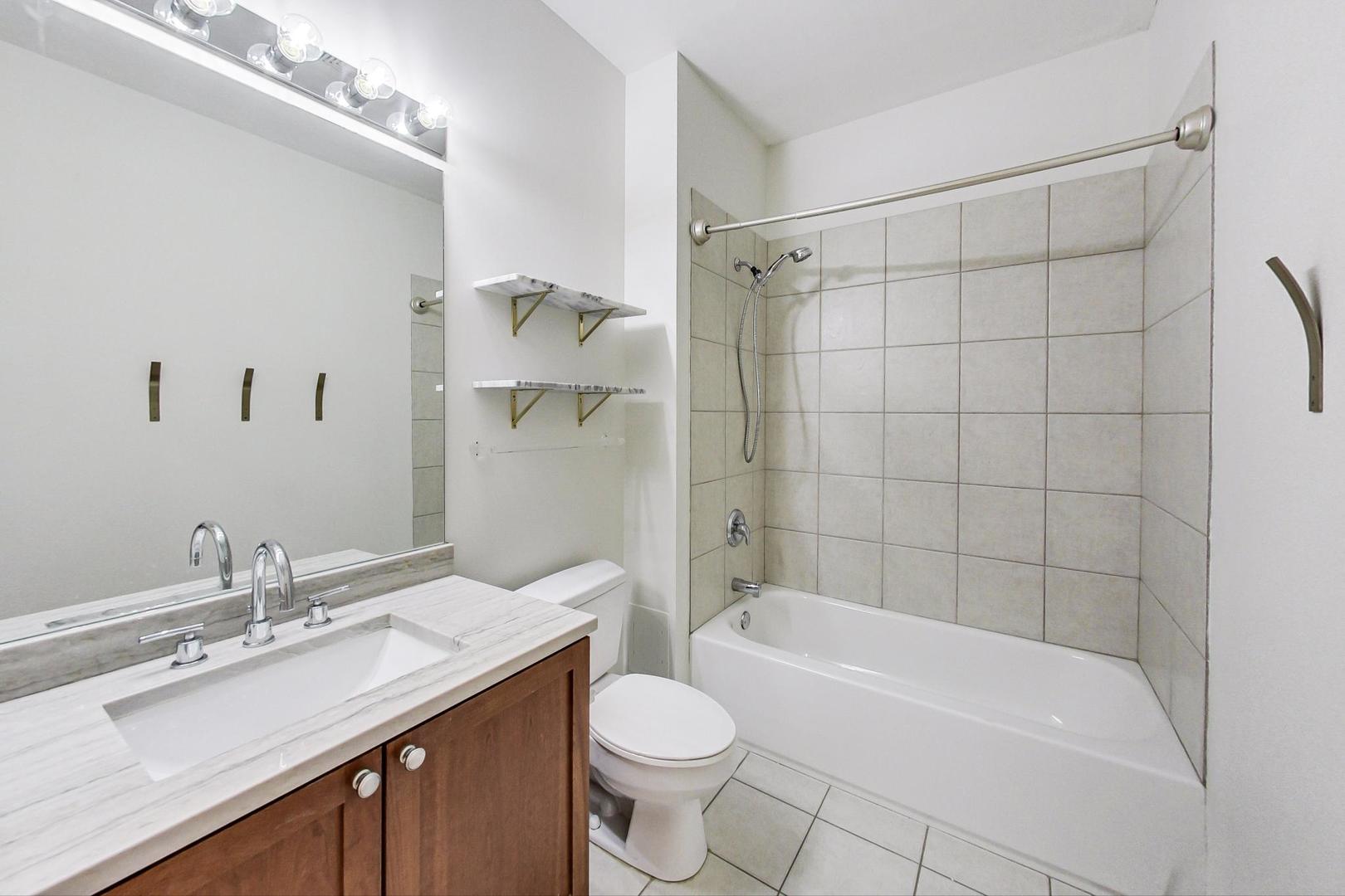950 West Monroe Street, Unit 608 Chicago, IL 60607 - Photo 32 of 44 a bathroom with a granite countertop sink toilet and shower