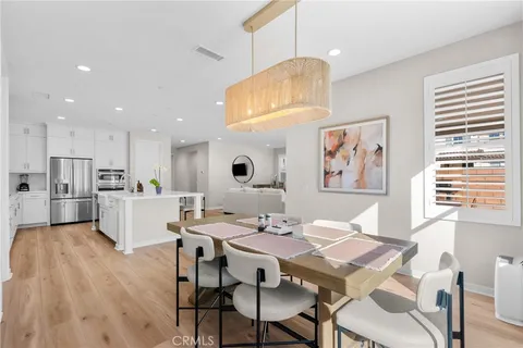 a view of a dining room with furniture a kitchen and chandelier