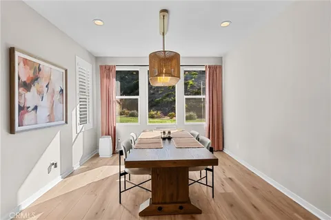 a dining room with wooden floor and large window