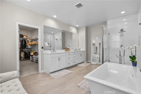 a spacious bathroom with a double vanity sink tub and mirror