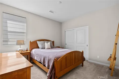 a view of a white house next to a yard with big trees