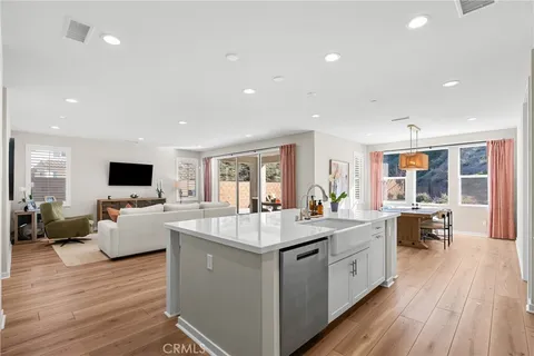 a large living room with stainless steel appliances granite countertop furniture and a wooden floor