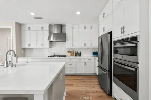 a kitchen with cabinets stainless steel appliances and a sink