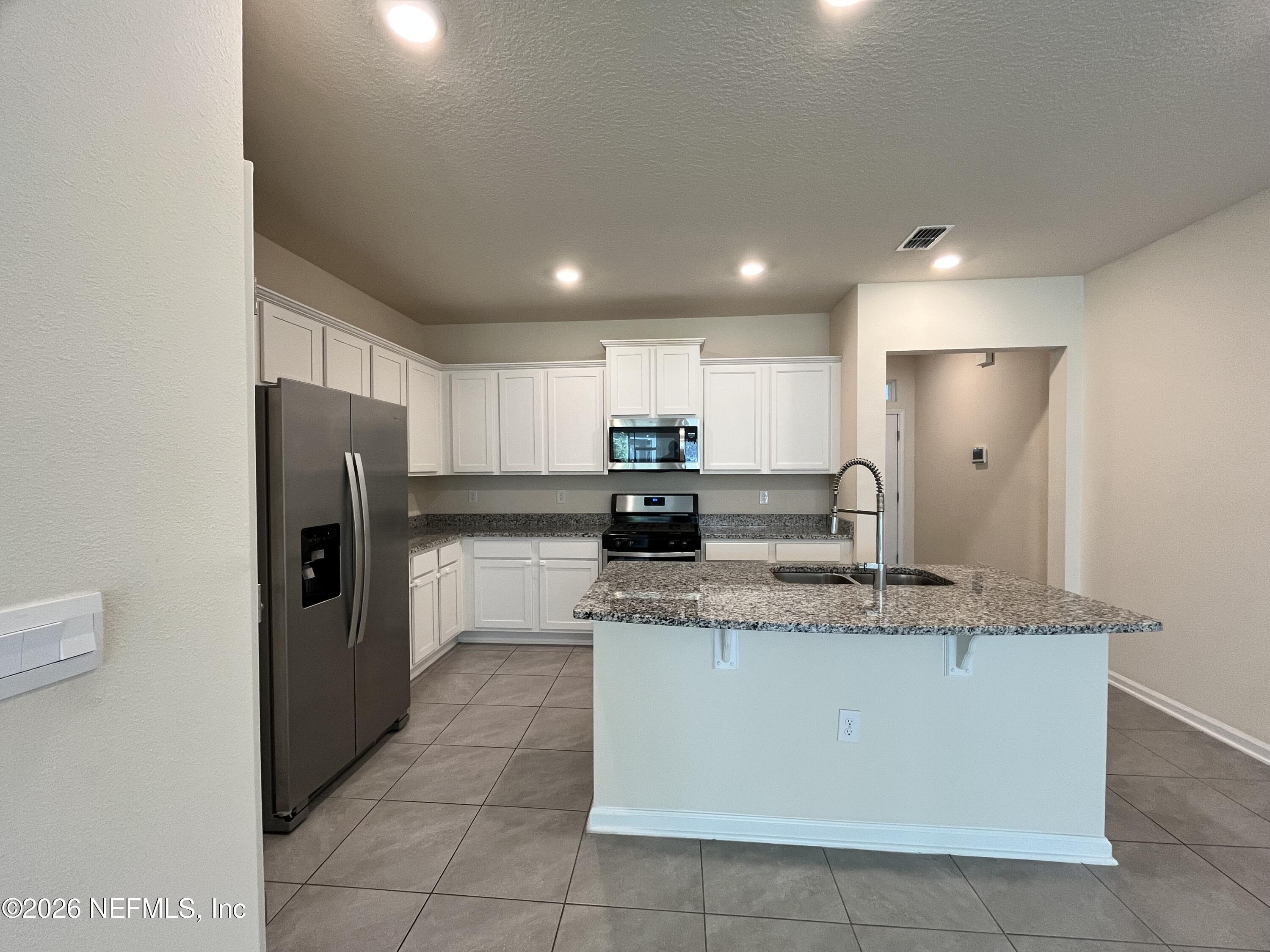 548 Coastline Way St. Augustine, FL 32092 - Photo 8 of 21 a large kitchen with stainless steel appliances granite countertop a refrigerator a sink a stove a microwave and a oven