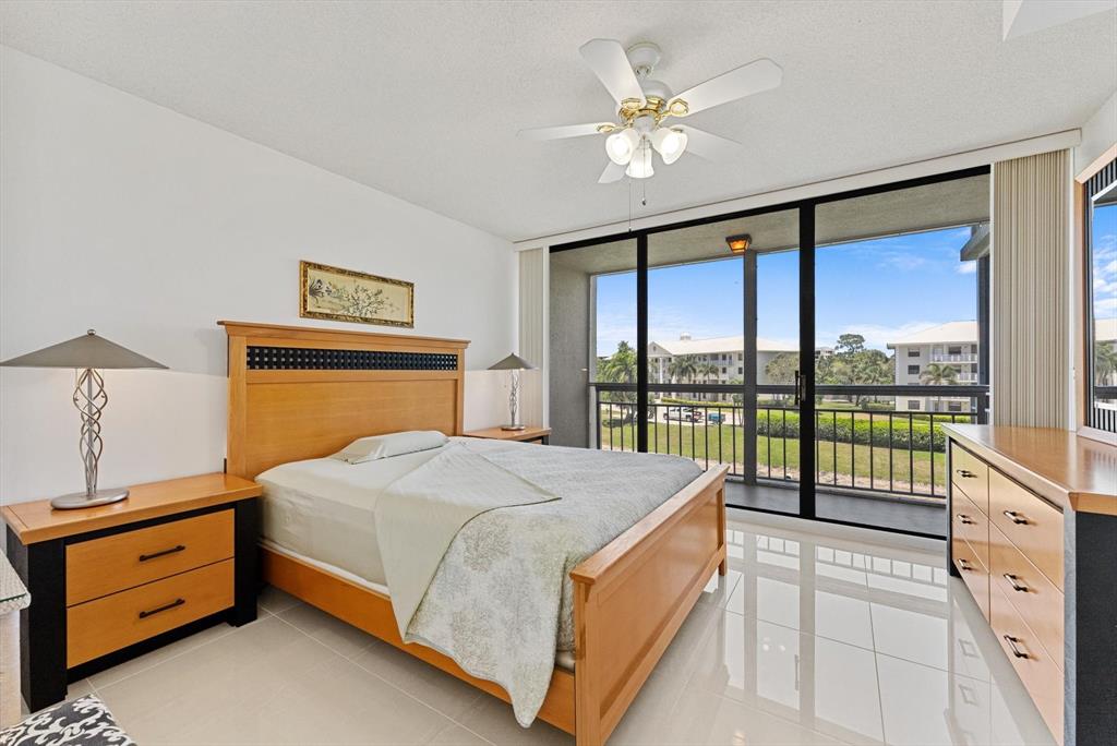 6217 Balboa Circle, Unit 305 Boca Raton, FL 33433 - Photo 14 of 28 a bedroom with a large bed and a tv on dresser