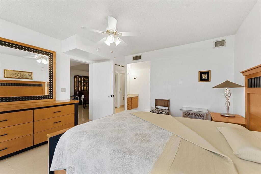 6217 Balboa Circle, Unit 305 Boca Raton, FL 33433 - Photo 15 of 28 a bedroom with a large bed and a chandelier