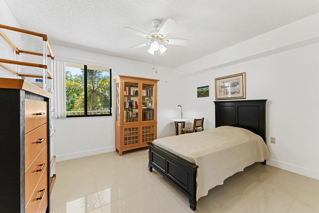 6217 Balboa Circle, Unit 305 Boca Raton, FL 33433 - Photo 18 of 28 a spacious bedroom with a bed and a table