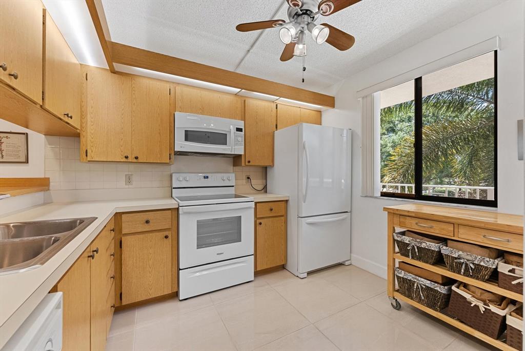 6217 Balboa Circle, Unit 305 Boca Raton, FL 33433 - Photo 6 of 28 a kitchen with a stove cabinets and a refrigerator