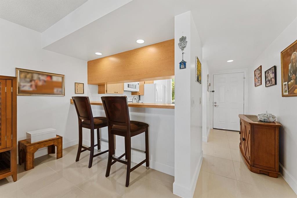 6217 Balboa Circle, Unit 305 Boca Raton, FL 33433 - Photo 8 of 28 a view of a dining room with furniture and a ceiling fan