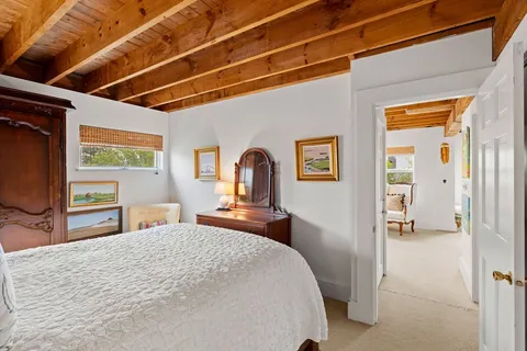 a bedroom with a bed and a large mirror on the dresser