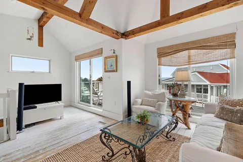a living room with furniture a flat screen tv and a floor to ceiling window