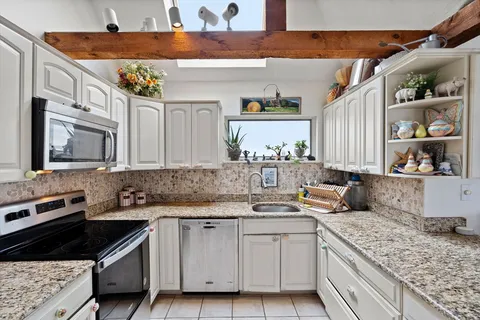 a kitchen with stainless steel appliances granite countertop a sink stove and cabinets