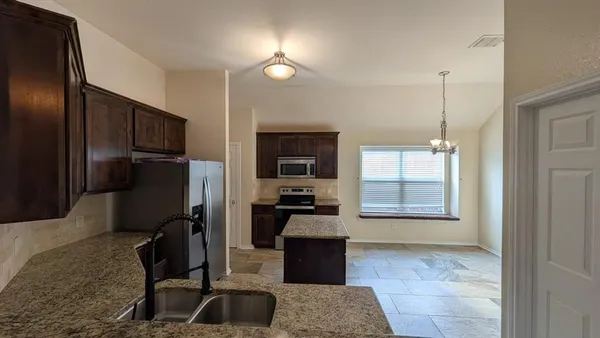 a kitchen with stainless steel appliances granite countertop a refrigerator and a sink