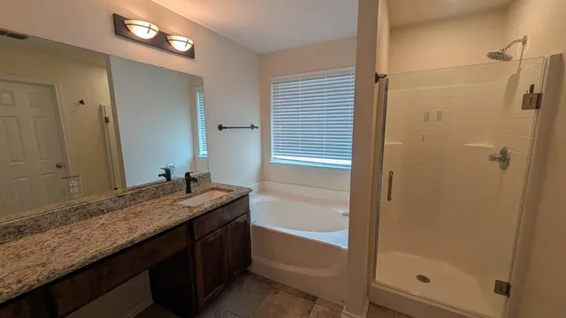 a bathroom with a granite countertop sink and a mirror