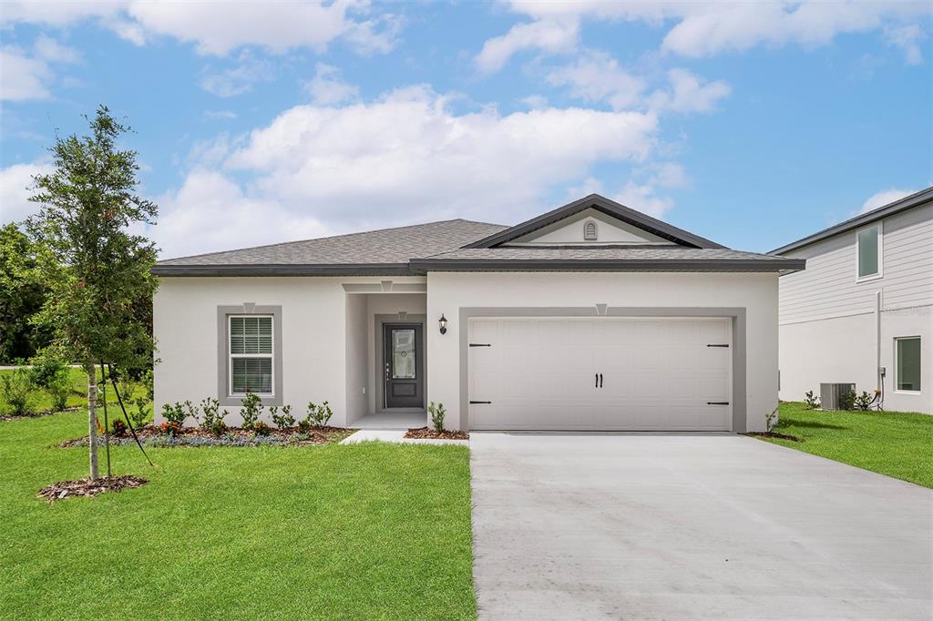 13352 Tula Loop Astatula, FL 34705 - Photo 1 of 19 a front view of a house with a garden and yard