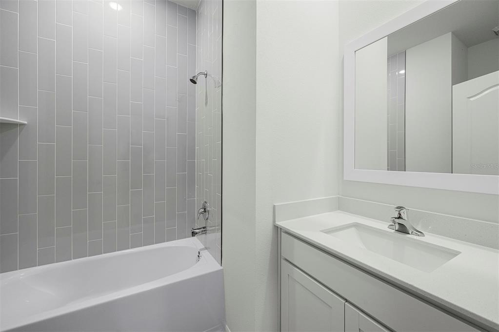 13352 Tula Loop Astatula, FL 34705 - Photo 17 of 19 a bathroom with a tub sink vanity granite and a mirror