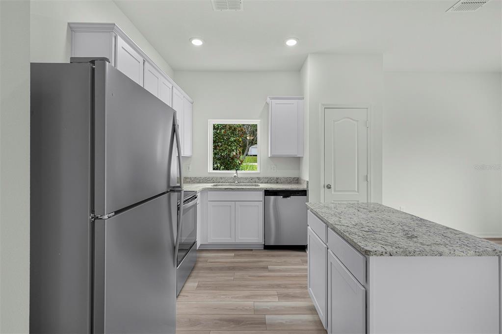 13352 Tula Loop Astatula, FL 34705 - Photo 6 of 19 a kitchen with stainless steel appliances granite countertop a refrigerator and a sink