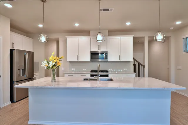a kitchen with kitchen island a center island a sink stainless steel appliances and cabinets