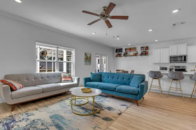 a living room with furniture and a wooden floor