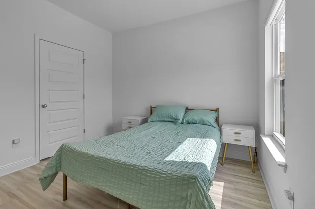 a bed sitting in a bedroom next to a window