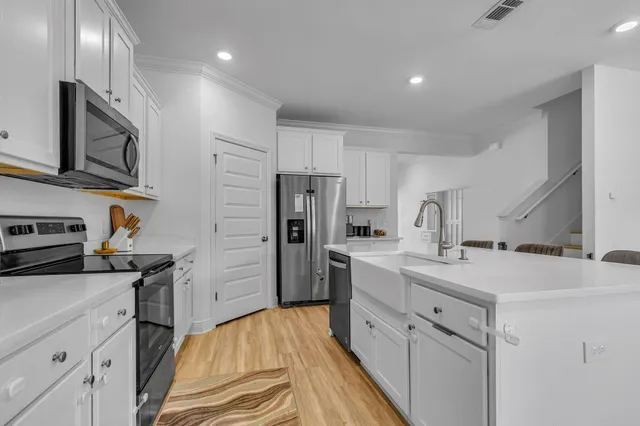 a kitchen with white cabinets and stainless steel appliances