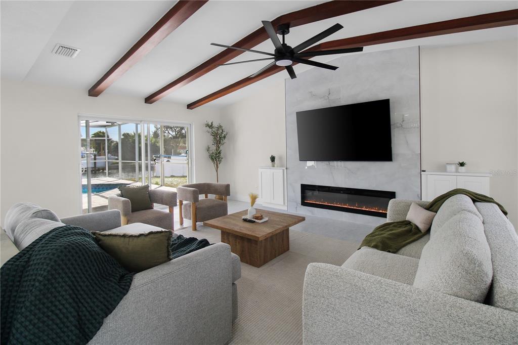1575 Brookside Boulevard Largo, FL 33770 - Photo 16 of 42 a living room with furniture a flat screen tv and a fireplace