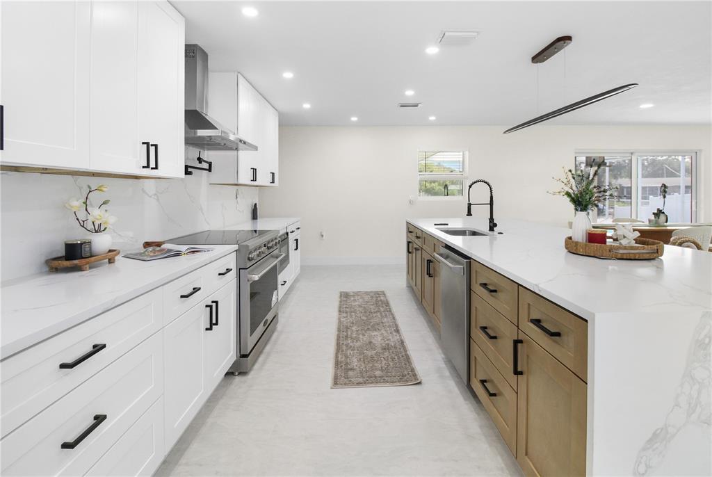 1575 Brookside Boulevard Largo, FL 33770 - Photo 8 of 42 a large kitchen with stainless steel appliances lots of counter space and wooden floor