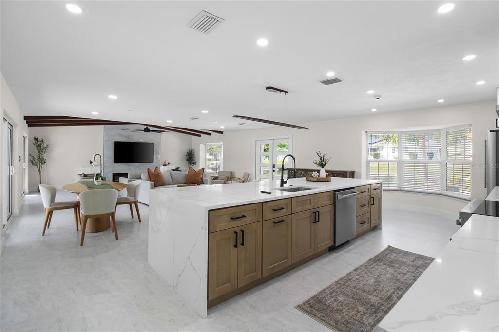 1575 Brookside Boulevard Largo, FL 33770 - Photo 10 of 42 a large white kitchen with a large island in the center a sink and a large window