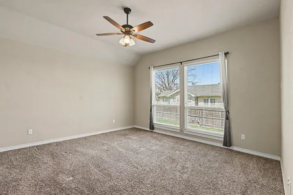 an empty room with a ceiling fan and window