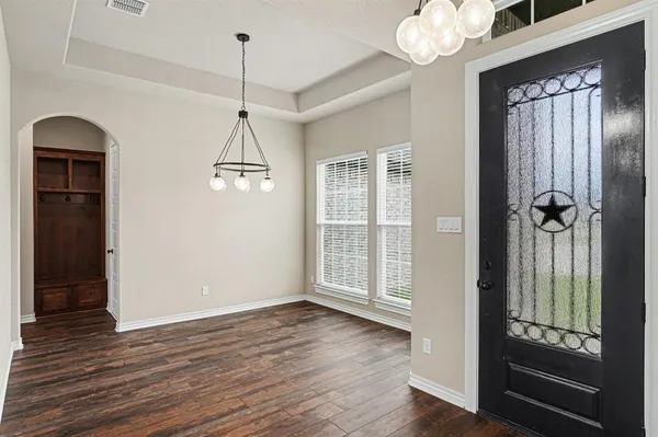 a view of an empty room with wooden floor fireplace and a window