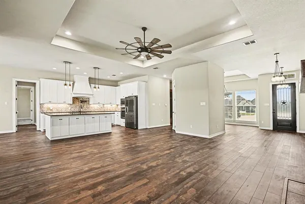 a kitchen with granite countertop a sink stainless steel appliances and white cabinets