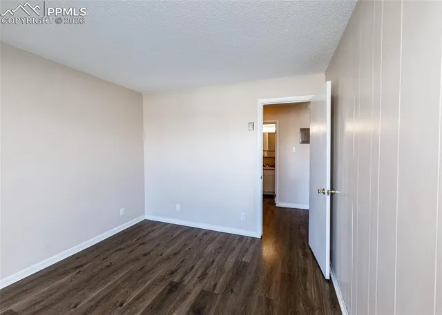an empty room with wooden floor and glass door