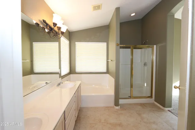 a spacious bathroom with a tub sink and mirror
