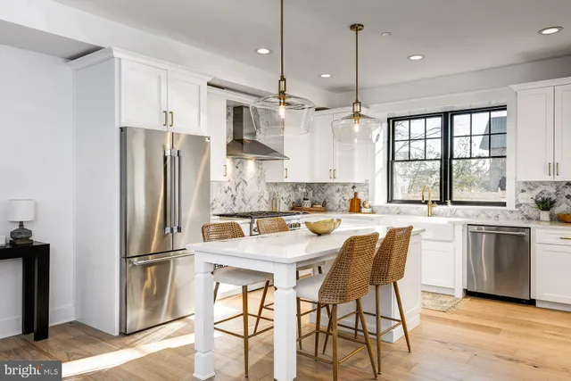 a kitchen with stainless steel appliances granite countertop a stove a sink and white cabinets