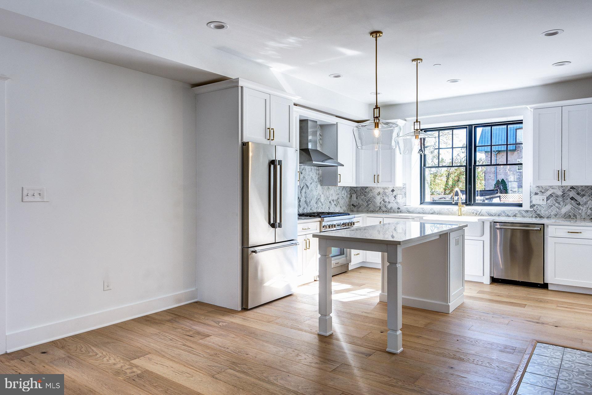 20 East Redman Avenue, Unit B Haddonfield, NJ 08033 - Photo 9 of 43 a kitchen with stainless steel appliances granite countertop a refrigerator a sink dishwasher a stove and white countertops with wooden floor