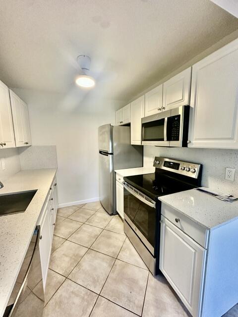 1047 Exeter C Boca Raton, FL 33434 - Photo 4 of 37 a kitchen with stainless steel appliances granite countertop a stove a sink and a refrigerator