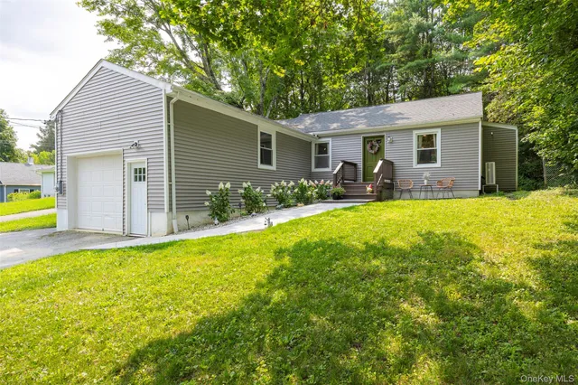 a view of a house with a yard and chairs