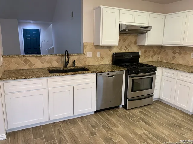 a kitchen with granite countertop a stove and a sink