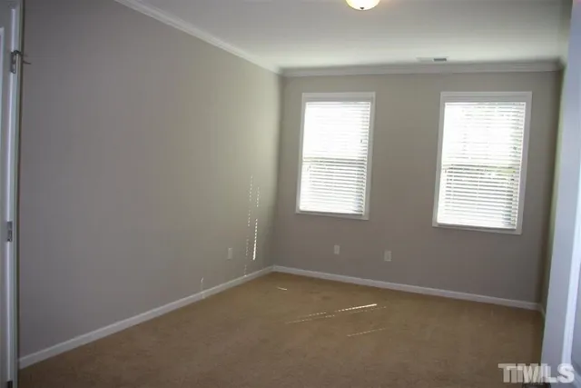 a view of an empty room with closet and wooden floor