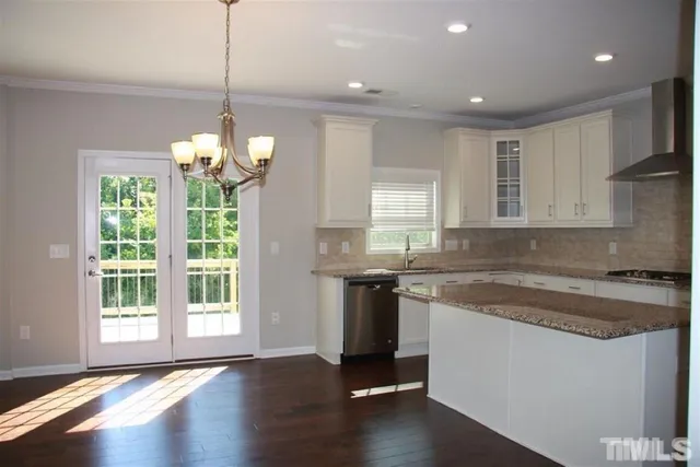a kitchen that has a lot of cabinets and wooden floor