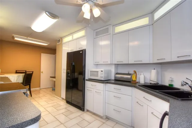 a kitchen with stainless steel appliances granite countertop a refrigerator and a sink