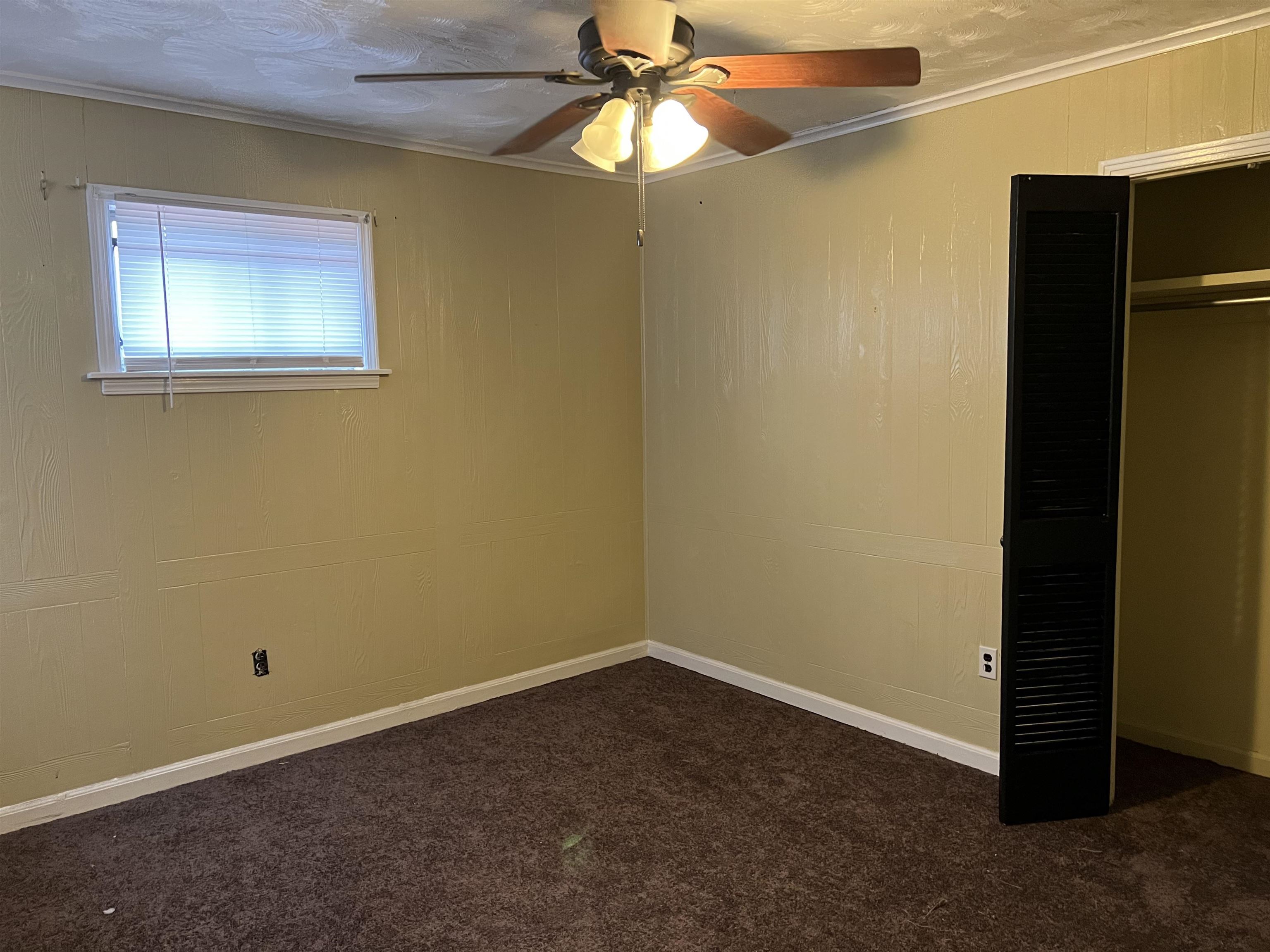 3548 Yokley Road Memphis, TN 38109 - Photo 8 of 16 Unfurnished bedroom featuring dark colored carpet, a closet, ceiling fan, and crown molding