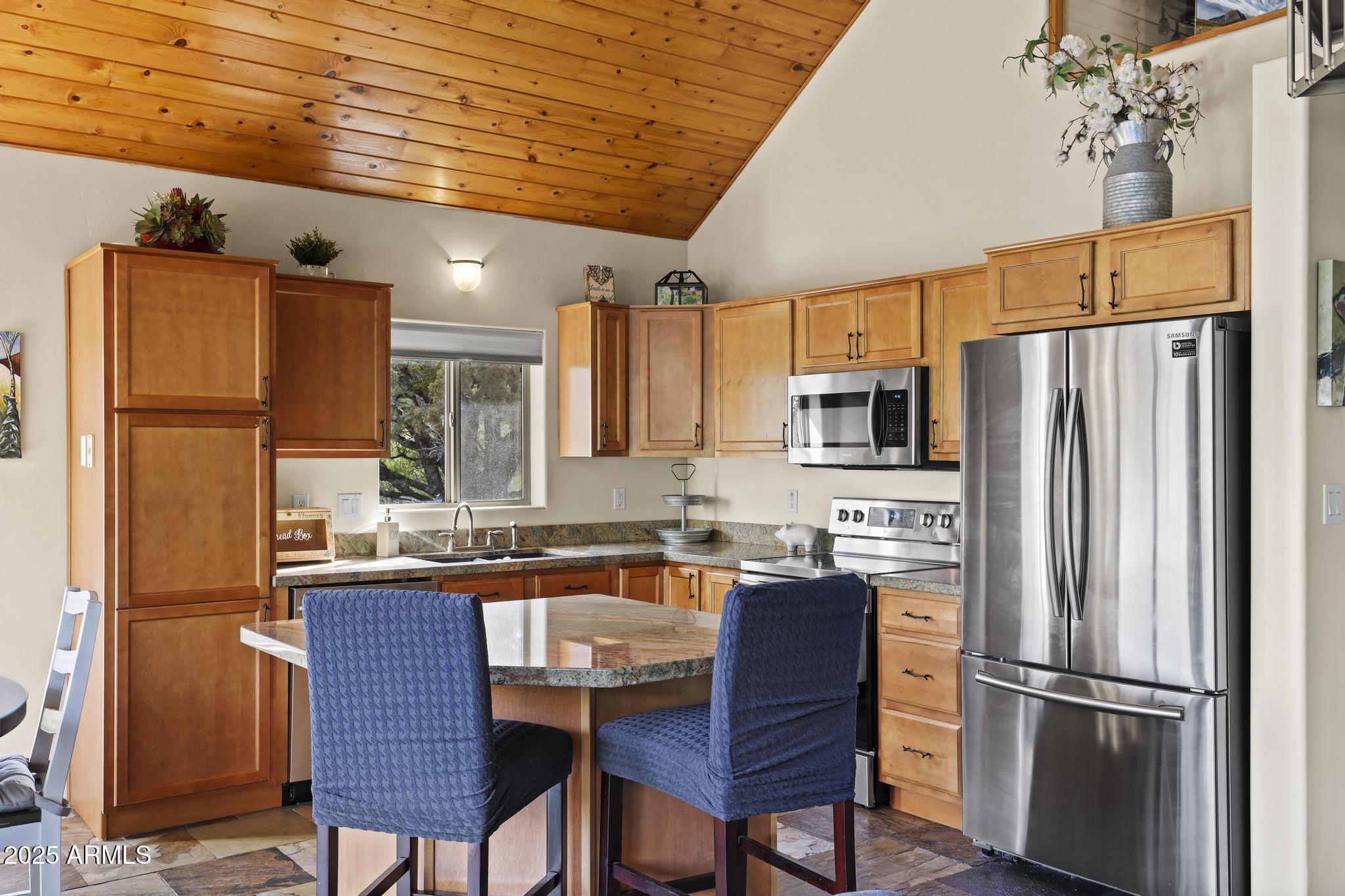 4977 North N Trails Pine, AZ 85544 - Photo 14 of 28 a kitchen with stainless steel appliances granite countertop a refrigerator a sink dishwasher a stove and a refrigerator with wooden floor