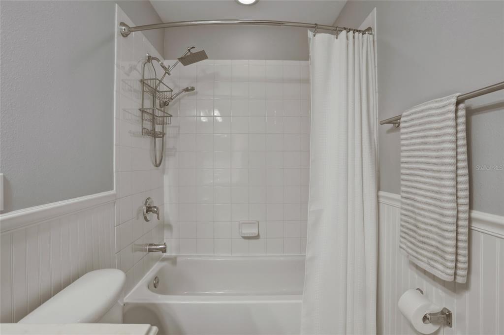 13013 Overstreet Road Windermere, FL 34786 - Photo 18 of 47 a bathroom with a bathtub and a shower