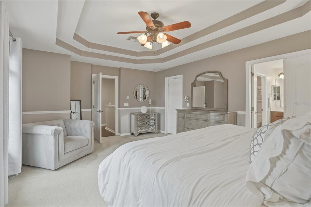 13013 Overstreet Road Windermere, FL 34786 - Photo 23 of 47 a spacious bedroom with a bed and ceiling fan
