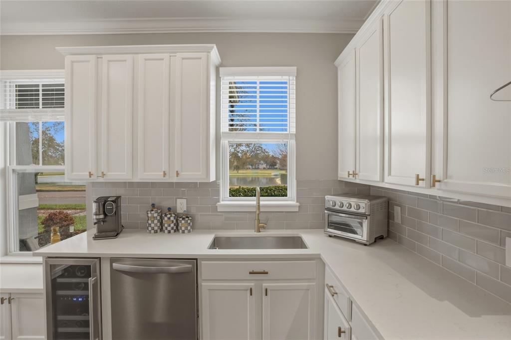 13013 Overstreet Road Windermere, FL 34786 - Photo 7 of 47 a kitchen with stainless steel appliances white cabinets and a window